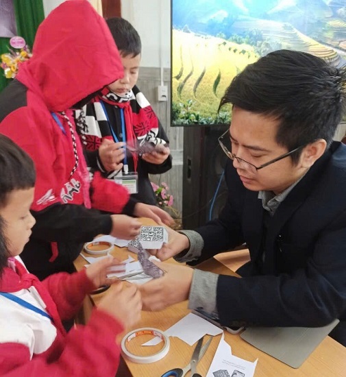 Th.S Nguyễn Trung Kiên hướng dẫn học sinh Trường phổ thông dân tộc nội trú THCS, THPT huyện Quản Bạ, thị trấn Tam Sơn, tỉnh Hà Giang, gấp hộp để trải nghiệm công nghệ thực tế ảo tăng cường. Ảnh: Lan Anh Th.S Nguyễn Trung Kiên hướng dẫn học sinh Trường phổ thông dân tộc nội trú THCS, THPT huyện Quản Bạ, thị trấn Tam Sơn, tỉnh Hà Giang, gấp hộp để trải nghiệm công nghệ thực tế ảo tăng cường. Ảnh: Lan Anh